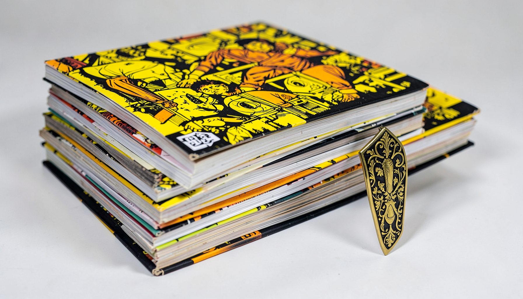 Pilha de livros de banda desenhada com uma lâmina decorativa ao lado, tons vivos de amarelo e preto, estilo gráfico arrojado